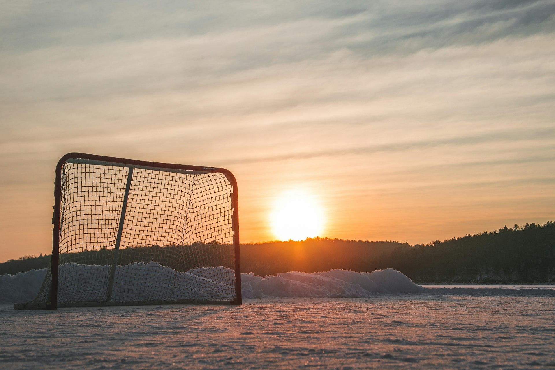 black metal frame on snow covered ground during sunset